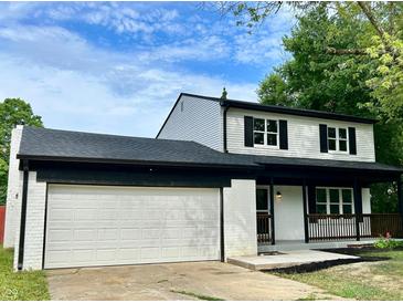 Updated two-story house with white brick, black roof, and a white garage door at 5619 Pappas Dr, Indianapolis, IN 46237