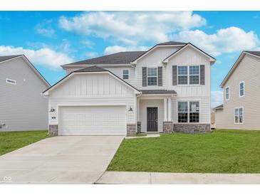Charming two-story home with a white exterior, stone accents, a two-car garage, and a well-manicured lawn at 7164 Firestone Rd, Whitestown, IN 46052