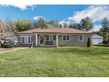 Ranch home with stone exterior, landscaped lawn, and detached garage at 2003 S Bolton Ave, Indianapolis, IN 46203