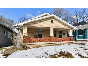 Charming bungalow with a brick front porch and tan siding at 3614 E New York St, Indianapolis, IN 46201