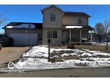 Two-story house with attached garage and covered porch. Landscaped yard with snowy patches at 4651 Maplelawn Dr, Columbus, IN 47203