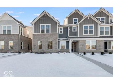 Two-story townhome with gray siding, white trim, and a snowy front yard at 5751 Cr W 750 N, McCordsville, IN 46055