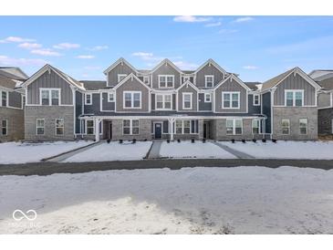 Three-story townhouses with gray siding, snow-covered yards, and charming front porches at 5763 Cr W 750 N, McCordsville, IN 46055