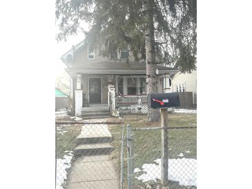 Quaint house with front porch, steps, and fenced yard at 1348 N Lasalle St, Indianapolis, IN 46201