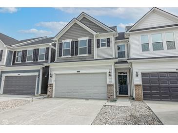 Two-story townhome with gray and white siding, gray garage door, and a brick base at 18655 Moray St, Westfield, IN 46069