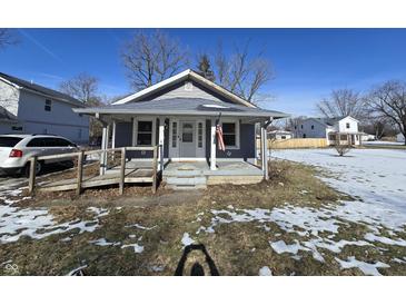 Gray bungalow with front porch, American flag, and small yard at 1942 E Edgewood Ave, Indianapolis, IN 46227