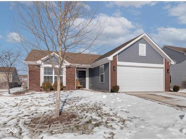 Brick and gray-sided home with a white garage door and landscaping at 2240 Mozart Dr, Greenfield, IN 46140