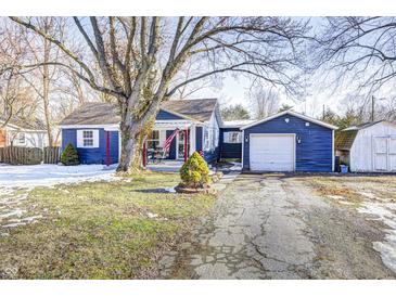 Charming blue house with a spacious yard and detached garage at 233 S Routiers Ave, Indianapolis, IN 46219