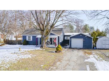 Charming one-story home with a covered porch, detached garage, and shed at 233 S Routiers Ave, Indianapolis, IN 46219