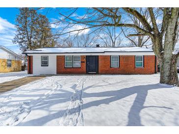 Charming brick home with a well-maintained yard and beautiful tree in a winter setting at 3647 Richelieu Rd, Indianapolis, IN 46226