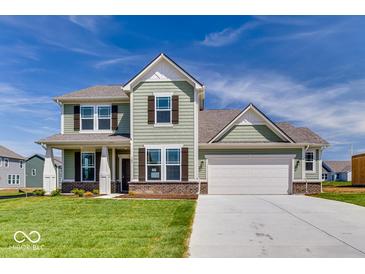 Charming two-story home with green siding, a well-manicured lawn, and a two-car garage at 385 N Post Oak Dr, Mooresville, IN 46158