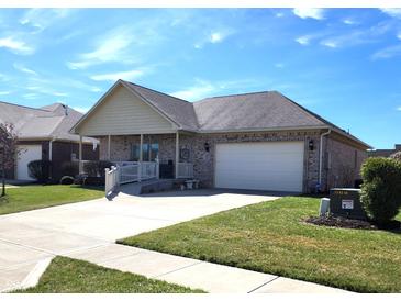 Charming brick home featuring an attached garage, a covered porch, and a well-maintained lawn at 5419 E Shae Lake Dr, Mooresville, IN 46158