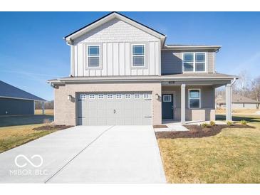 Charming two-story home featuring a two-car garage, gray brick, gray siding, a covered porch and a well-manicured lawn at 5592 Cattail Branch Ln, Clayton, IN 46118