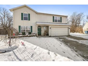 Two-story house with a green door and attached garage, snow-covered yard at 1830 Sweet Blossom Ln, Indianapolis, IN 46229