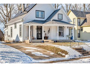 White house with solar panels, porch, and snow-covered yard at 3816 Rookwood Ave, Indianapolis, IN 46208