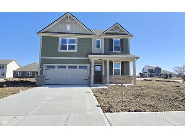 Two-story home with a two-car garage, manicured lawn, and welcoming front porch at 8703 Duncan St, Fortville, IN 46040