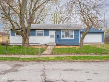 Charming blue and white one story home with a detached garage, curb appeal, and freshly landscaped yard at 2814 S Randolph St, Indianapolis, IN 46203