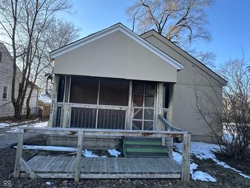 Tan house with screened porch and wooden steps, needs some TLC at 3512 N Keystone Ave, Indianapolis, IN 46218