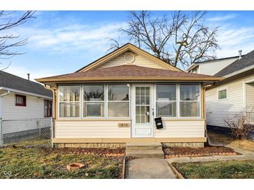 Charming home featuring a sunroom with ample windows and a well-maintained yard at 1028 Albany St, Indianapolis, IN 46203