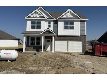 Two-story home showcasing a brick and vinyl exterior, a two-car garage, and modern architectural details at 2162 Warbler St, Danville, IN 46122