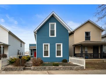Charming blue two-story home featuring a well-manicured yard and classic architectural details at 1130 S Senate Ave, Indianapolis, IN 46225