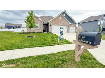 Charming brick home featuring a three-car garage, manicured lawn, and inviting curb appeal at 2394 Eagle Ave, Plainfield, IN 46168