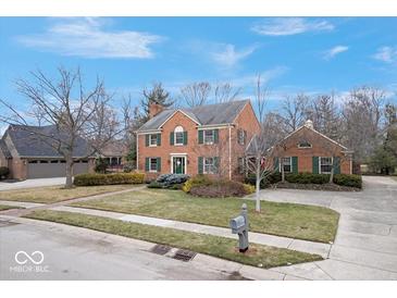 Charming two-story brick home with green shutters and a well-manicured lawn at 6551 Forrest Commons Blvd, Indianapolis, IN 46277