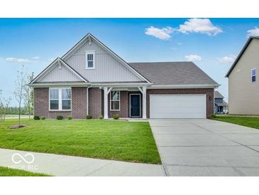 Charming brick home featuring a well-manicured lawn, attached two car garage, and stylish architectural details at 1020 Stonehaven Dr, Indianapolis, IN 46239