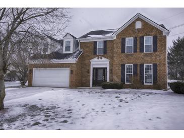 Two story brick home with attached garage and snowy front yard at 415 Calamus Ct, Indianapolis, IN 46239