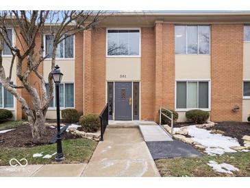 Brick building exterior with gray door, accessible ramp, and landscaping at 581 W Hunters Dr # Apt D, Carmel, IN 46032