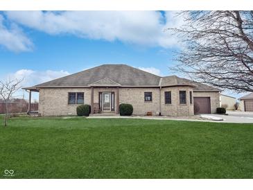 Brick ranch house with a large yard, attached garage, and inviting front entrance at 7675 E 500 N, Lebanon, IN 46052