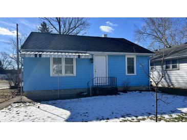 Charming blue house with a white door and awning, nestled on a lot with a small lawn at 901 W Marsh St, Muncie, IN 47303