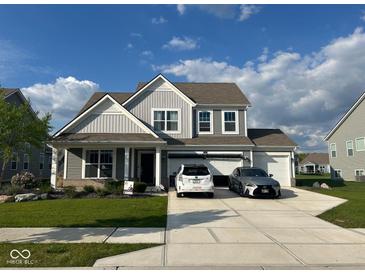 Charming two-story home boasts a three car garage, and a beautifully landscaped front yard, creating curb appeal at 9426 Orchard Cove Dr, Indianapolis, IN 46239