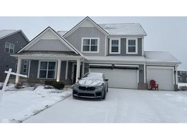 Two-story house with gray siding, snowy driveway, and attached garage at 9426 Orchard Cove Dr, Indianapolis, IN 46239