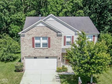 Charming two-story home with a brick facade, attached two-car garage, and nicely landscaped front yard at 10391 Butler Dr, Brownsburg, IN 46112