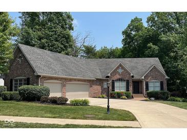 Charming brick home with a well-manicured lawn, two-car garage, and lush landscaping at 11253 Loch Raven Blvd, Fishers, IN 46037