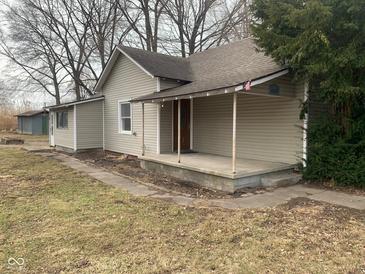 Beige house with covered porch and well-maintained lawn at 12625 Strawtown Ave, Noblesville, IN 46060