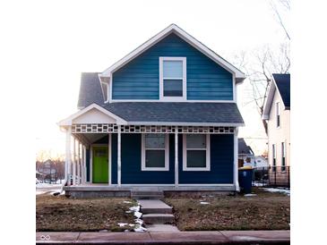Charming two-story blue house with white trim, front porch, and a lime green door at 2502 N Harding N St, Indianapolis, IN 46208