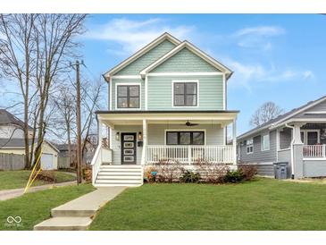Charming two-story home featuring a welcoming front porch, well-manicured lawn, and beautiful architectural details at 1224 Keystone Ave, Indianapolis, IN 46201