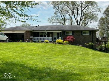 Brick ranch house with a large yard, attached garage, and deck at 3163 S 25 E, Shelbyville, IN 46176
