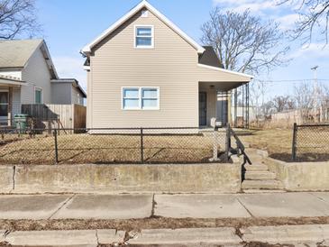 Beige house with a front porch and chain link fence at 320 W 6Th St, Muncie, IN 47302