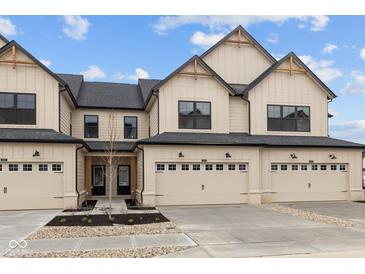 Attractive townhouse featuring a two-car garage and modern architectural details under a blue sky at 4183 Douro Trl, Westfield, IN 46062