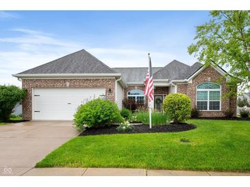 Charming brick home featuring a well-manicured lawn, tidy landscaping, and an attached two car garage at 8535 Blue Marlin Dr, Indianapolis, IN 46239