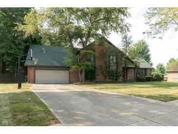 Brick house with green roof, attached garage, and basketball hoop at 877 Revere Ct, Greenwood, IN 46142
