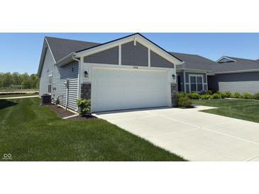 Charming home with a spacious two-car garage and concrete driveway, surrounded by well-manicured lawn and landscaping at 19438 Astoria Ave, Sheridan, IN 46069