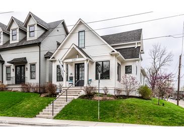 Charming two-story home with white siding, black trim, landscaped yard, and inviting front porch at 2301 Nowland Ave, Indianapolis, IN 46201