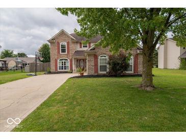 Brick house with red shutters, landscaping, and a driveway at 57 Sebring Ct, Whiteland, IN 46184