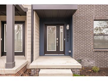 Modern townhome exterior with brick and siding, featuring a covered entryway at 9893 Greenvine Dr, Carmel, IN 46032