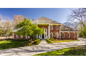 Stunning brick home with a symmetrical design, white trim windows, and a well-manicured lawn at 7341 Washington Blvd, Indianapolis, IN 46240