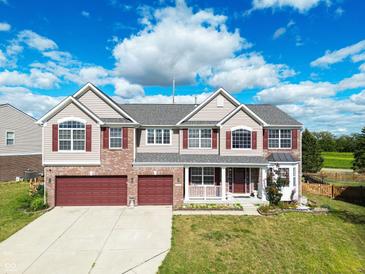 Two-story brick home with red accents and a two-car garage at 10723 Pokagon Way, Indianapolis, IN 46239
